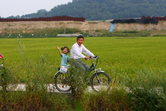 노무현 전 대통령이 퇴임 후 봉하마을에서 손녀 노서은양을 태우고 자전거를 타는 모습/사진=노무현재단 제공