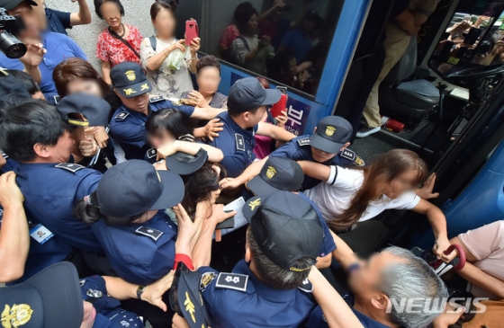 12일 오전 제주지법에서 전 남편을 잔혹하게 살해한 뒤 시신을 훼손·유기한 혐의를 받는 고유정(36)의 첫 공판이 열린 가운데 시민들이 호송차에 오르는 고유정의 머리채를 잡아 당기고 있다.  2019.08.12.  /사진=뉴시스