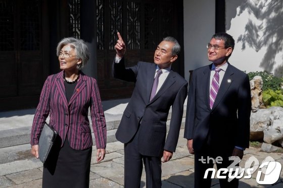 (베이징 AFP=뉴스1) 우동명 기자 = 강경화 외교부 장관이 21일(현지시간) 베이징 구베이 타운에서 한중일 외교장관 회의에 앞서 왕이 중국 외교 담당 국무위원 겸 외교부장, 고노 다로 일본 외무상과 얘기를 나누고 있다. © AFP=뉴스1 <저작권자 © 뉴스1코리아, 무단전재 및 재배포 금지>