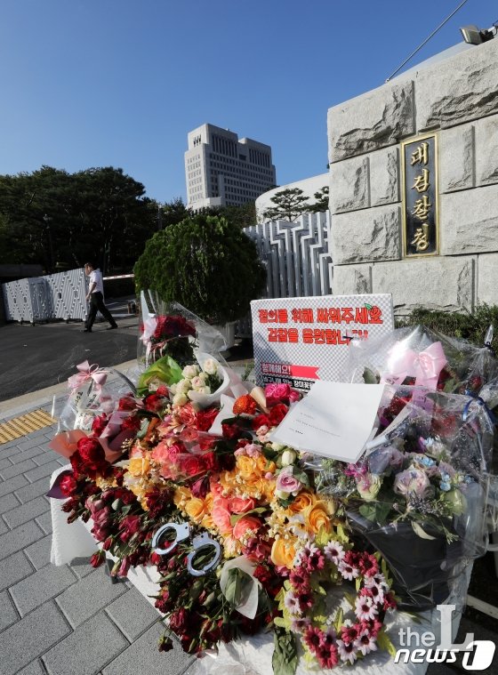 (서울=뉴스1) 이승배 기자 = 조국 법무부 장관 일가 사모펀드 의혹의 '키맨'으로 지목된 조 장관의 5촌 조카 조모씨가 지난 14일 새벽 인천국제공항에서 검찰에 체포돼 조사 받고 있다. 검찰은 조씨가 조 장관 일가 사모펀드 의혹 뿐만 아니라 이를 둘러싼 다수 의혹을 규명할 핵심 인물로 보고 조사를 진행 중인 것으로 알려졌으며, 이르면 15일 구속영장을 청구할 것으로 예상된다. 사진은 15일 오전 서울 서초구 대검찰청 앞 검찰을 응원하는 꽃다발들의 모습. 2019.9.15/뉴스1 <저작권자 © 뉴스1코리아, 무단전재 및 재배포 금지>