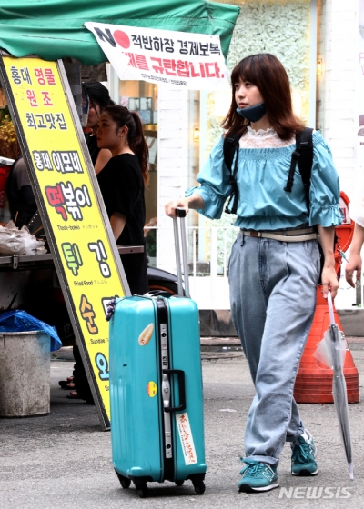 지난7월 오전 서울 마포구 홍대입구역 인근 일본의 경제보복을 규탄하는 현수막이 붙은 노점상 매대 앞을 일본인 관광객이 지나가고 있다. /사진=뉴시스