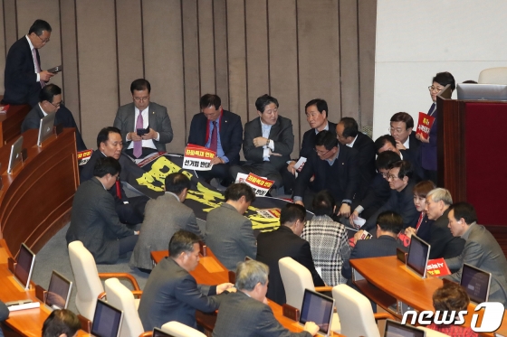 (서울=뉴스1) 임세영 기자 = 자유한국당 의원들이 27일 서울 여의도 국회 본회의장에서 제373회 국회(임시회) 제1차 본회의 개의를 막기위해 의장석을 둘러싸고 있다. 이날 국회에서는 선거법이 표결에 붙여질 예정이다. 2019.12.27/뉴스1 <저작권자 © 뉴스1코리아, 무단전재 및 재배포 금지>