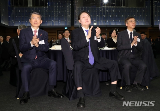 [서울=뉴시스박영태 기자 = 윤석열 검찰총장이 2일 오전 서울시 중구 대한상공회의소 국제회의장에서 열린 대통령과 함께하는 2020 경자년 신년회에 참석해 문재인 대통령의 신년 인사말에 박수를 치고 있다. 왼쪽부터 은성수 금융위원장, 윤 총장, 장완익 사회적참사 조사위원장. 2020.01.02.   since1999@newsis.com