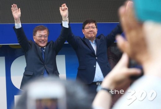 문재인 더불어민주당 대선후보가 18일 오후 광주광역시 동구 충장로 입구에서 열린 집중유세에서 고 김대중 전 대통령의 삼남 김홍걸 국민통합위원장과 손을 잡고 환호에 답하고 있다./사진=이동훈 기자