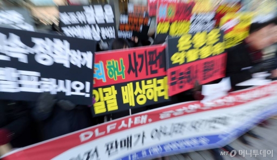 지난해 12월 'DLF 피해자 대책위원회' 관계자들이 서울 여의도 금융감독원 앞에서 입장을 발표하고 손피켓을 들어보인 모습./사진=김창현 기자 chmt@
