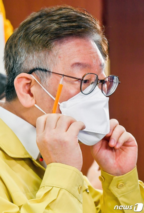 (수원=뉴스1) 경기사진공동취재단 = 이재명 경기도지사가 1일 오전 경기도 수원시 팔달구 경기도청에서 경기도 재난 기본소득 지급방식 및 사용 방법 관련 브리핑을 하던 중 마스크를 고쳐 쓰고 있다. 2020.4.1/뉴스1