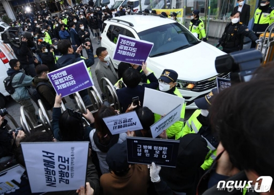 (서울=뉴스1) 송원영 기자 = 인터넷 메신저 텔레그램에서 미성년자를 포함한 여성들의 성 착취물을 제작 및 유포한 혐의를 받는 '박사방' 운영자 조주빈(25)이 25일 서울 종로구 종로경찰서 유치장에서 나와 검찰 유치장으로 향하자 시민들이 조주빈의 강력처벌을 촉구하며 피켓 시위를 하고 있다.  이날 경찰은 국민의 알권리, 동종범죄 재범방지 및 범죄예방 차원에서 신상을 공개했다. 2020.3.25/뉴스1