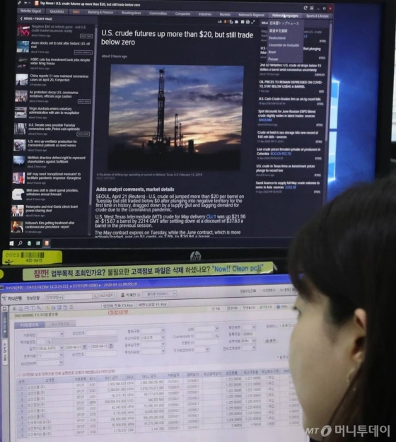 [서울=뉴시스] 전진환 기자 = 미국산 원유를 중심으로한 국제유가가 폭락한 21일 오전 서울 중구 하나은행 딜링룸에서 한 딜러가 유가 폭락 관련 기사를 열어놓고 업무를 보고 있다. 20일(현지시간) 뉴욕상업거래소(Nymex)에서 5월 인도분 서부텍사스산원유(WTI)는 배럴당 -37.63달러에 마감했다. 전 거래일 마감가(18.27달러) 대비 300% 넘게 폭락한 수치다. 2020.04.21.   amin2@newsis.com