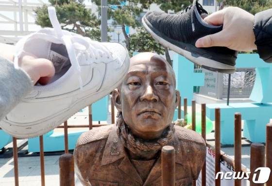 광주 동구 5·18민주광장에 설치된 '무릎꿇은 전두환 동상'을 시민들이 신발로 내리치는 퍼포먼스를 하고 있다.