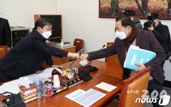 (서울=뉴스1) 임세영 기자 = 전해철 더불어민주당 간사(왼쪽)과 이종배 미래통합당 간사가 15일 오후 서울 여의도 국회에서 열린 추가경정예산안 등 조정소위원회 심사와 관련한 회의에서 주먹을 맞대고 인사를 나누고 있다. 2020.3.15/뉴스1