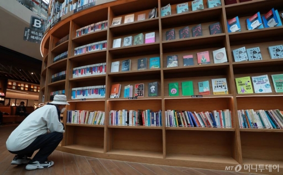 [서울=뉴시스] 이영환 기자 = 세계 책의 날인 23일 오후 서울 강남구 스타필드 코엑스몰 별마당도서관에서 한 시민이 책을 고르고 있다. 2020.04.23.     20hwan@newsis.com