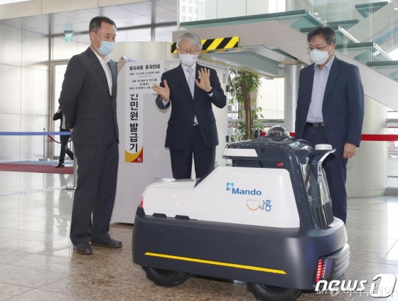 (서울=뉴스1) 김진환 기자 = 최기영 과기정통부 장관(가운데)이 13일 오전 서울 중구 서울중앙우체국에서 열린 자율주행 로봇 전시 및 시연에 참석해 순찰 로봇에 대해 설명을 듣고 있다. 2020.5.13/뉴스1