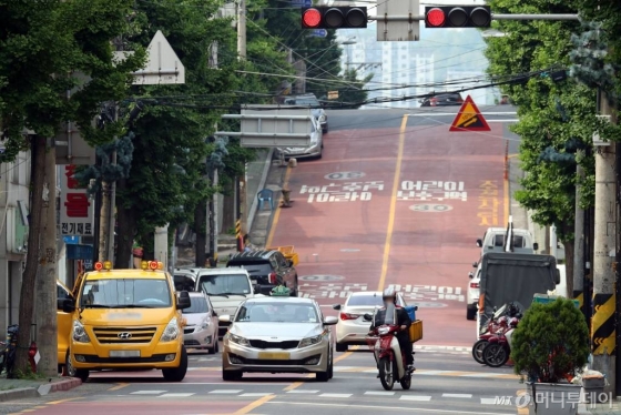 '민식이법' 시행 이후 어린이 보호구역에서 첫 사망 사고가 발생한 가운데 22일 인천의 한 어린이 보호구역에서 한 배달 오토바이가 신호를 무시한 채 중앙선을 넘어 주행하고 있다. / 사진=이기범 기자 leekb@