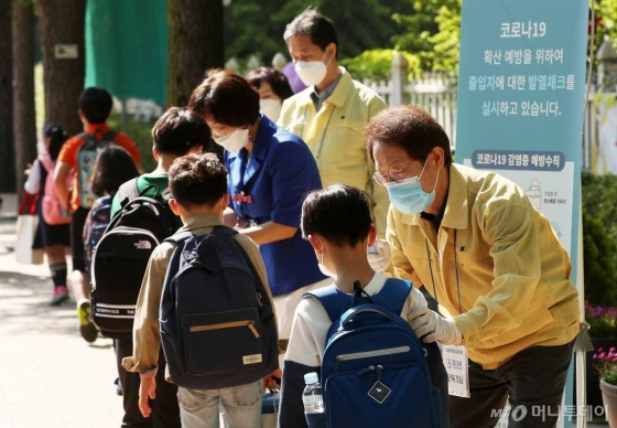 초등학교 1-2학년의 등교개학이 시작된 27일 오전 서울 송파구 세륜초등학교에서 조희연 서울시교육감이 학생들의 체온을 측정하고 있다. / 사진=김휘선 기자 hwijpg@
