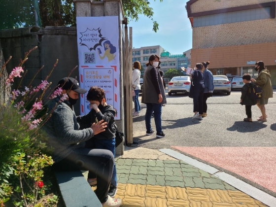 27일 서울 구로구 소재 한 초등학교 앞에서 첫 등교가 두려운 아이를 학부모가 달래고 있는 모습. /사진=정한결 기자.