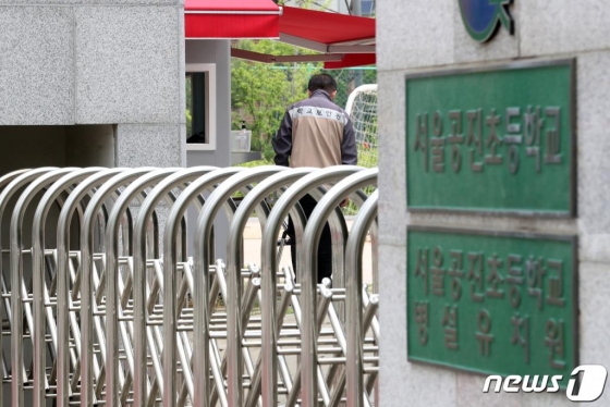 (서울=뉴스1) 이동해 기자 = 강서구 일대 학교 및 유치원 대다수의 등교가 내주로 미뤄진 지난 26일 코로나19 확진 판정을 받은 미술학원 강사와 유치원생이 다닌 미술학원 인근에 위치한 서울 강서구 서울공진초등학교에서 학교 보안관이 멍하니 운동장을 바라보고 있다.  조희연 서울시교육감은 오는 27일 고2·중3·초1~2·유치원생의 등교 개학을 하루 앞두고 "내일로 다가온 유치원과 초등학교의 등교 개학을 앞두고 강서구 학원발 감염 사태가 발생했다'며 "(일대) 다수 학교가 등교수업 일자를 다음 주로 조정할 예정"이라고 밝혔다. 2020.5.26/뉴스1