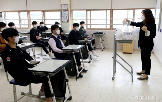 신종 코로나바이러스 감염증(코로나19) 여파로 등교가 5차례나 연기되며 80일 만에 등교 수업이 시작된 20일 오전 서울 시내의 한 고등학교 3학년 학생들이 교실에서 담임 선생님에게 방역 물품에 대한 설명을 듣고 있다. 2020.5.20 / 사진=김휘선 기자 hwijpg@