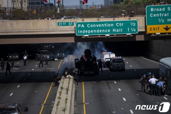 (필라델피아 AFP=뉴스1) 우동명 기자 = 1일(현지시간) 펜실베이니아주 필라델피아에서 흑인 남성 조지 플로이드의 사망에 항의하는 시위대와 경찰의 충돌 중 체포된 시민이 중앙분리대 위에 앉아 있다.  ⓒ AFP=뉴스1