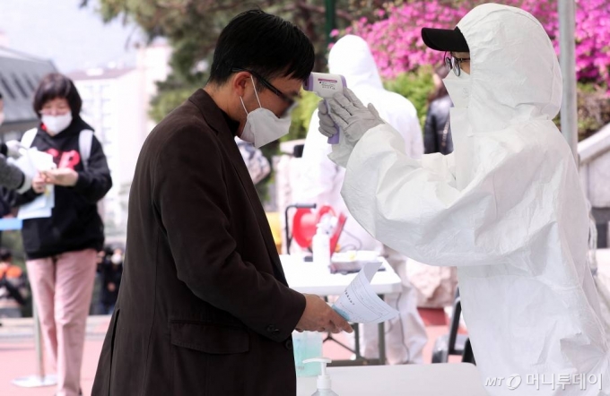 '코로나19' 예방을 위해 중단됐던 보험설계사 자격시험이 25일 서울 성북구 서경대학교 운동장에서 치러지는 가운데 응시자들이 입장 전 발열체크를 하고 있다. / 사진=김휘선 기자 hwijpg@