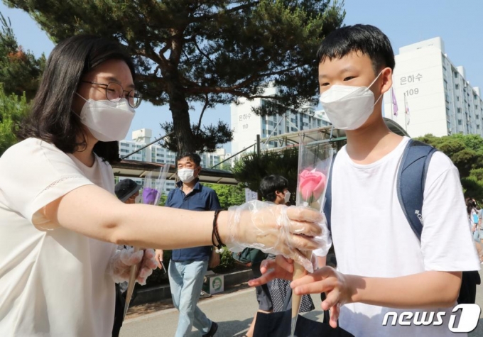 (대전=뉴스1) 김기태 기자 = 중1, 초 5, 6 학년의 등교 개학이 시작된 8일 오전 대전 서구 둔산초등학교에서 학생들이 장미꽃을 받으며 등교하고 있다. 2020.6.8/뉴스1