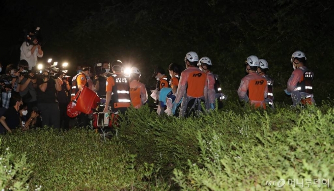 박원순 서울시장이 9일 오후 실종 신고가 접수된 뒤 7시간 만에 숨진채 발견된 10일 새벽 서울 종로구 와룡공원에서 구급대원들이 빈 들것을 들고 공원을 빠져나가고 있다. / 사진=김휘선 기자 hwijpg@
