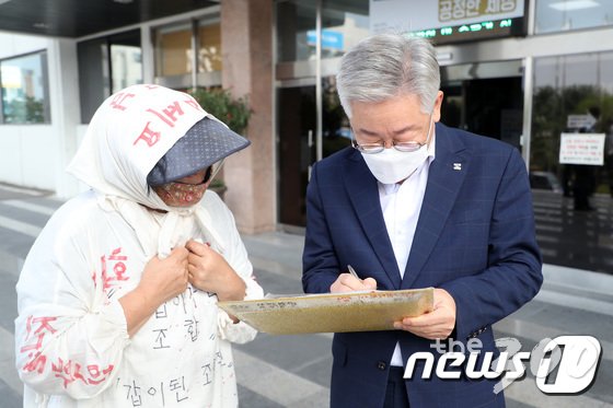 이재명 경기도지사가 17일 오전 경기도 수원시 팔달구 경기도청으로 출근하던 중 민원인의 연락처를 받아 적고 있다./사진=뉴스1