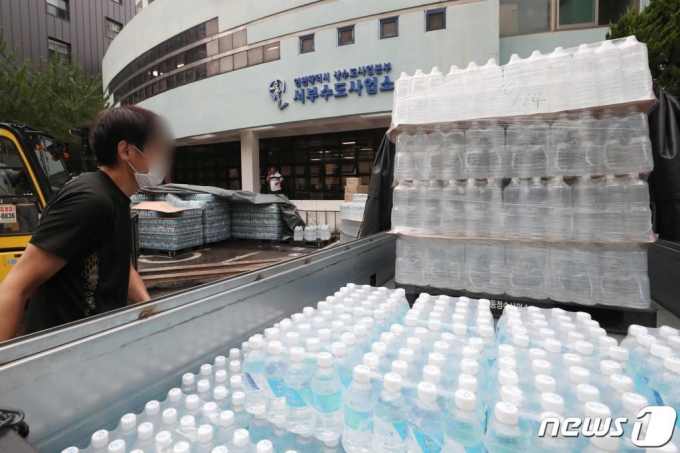 (인천=뉴스1) 민경석 기자 = 인천시와 부평구가 부평정수장 등 부평권역 배수지 3곳에서 죽은 깔따구 유충으로 추정되는 물체를 발견했다고 19일 밝혔다. 부평정수장에선 앞서 두 차례의 조사에서 유충이 확인되지 않았으나 최근 조사에서 배수지에서 유충 추정 물체가 확인됐고, 추가 정밀조사에서 죽은 물체가 발견됐다. 20일 인천 서구 서부수도사업소에서 직원들이 지역 구민에게 돌아갈 생수를 차량에 싣고 있다. 2020.7.20/뉴스1