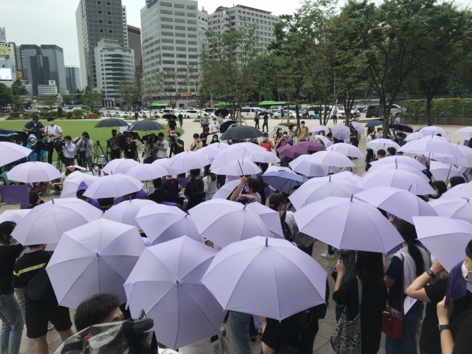 참석자들이 보라색 우산을 펼쳐든 채 집회를 진행하고 있다./사진=이정현 기자