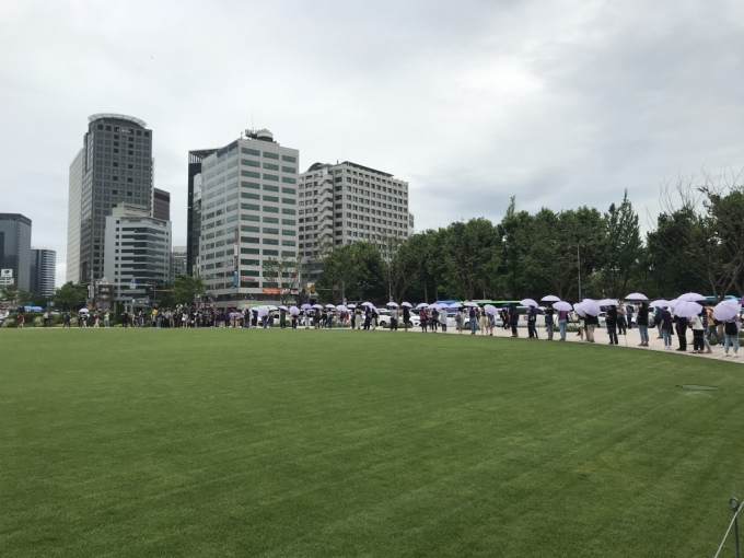 참석자들이 보라색 우산을 펼쳐들고 서울시청 광장 앞에서 국가인권위원회까지 행진을 준비하고 있다./사진=이정현 기자