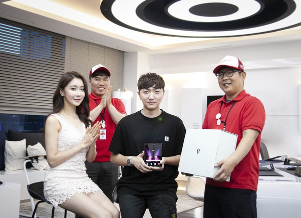 안진우씨(가운데)가 SK텔레콤으로부터 갤럭시 폴드 5G 단말을 배송받는 모습. /SK텔레콤 제공