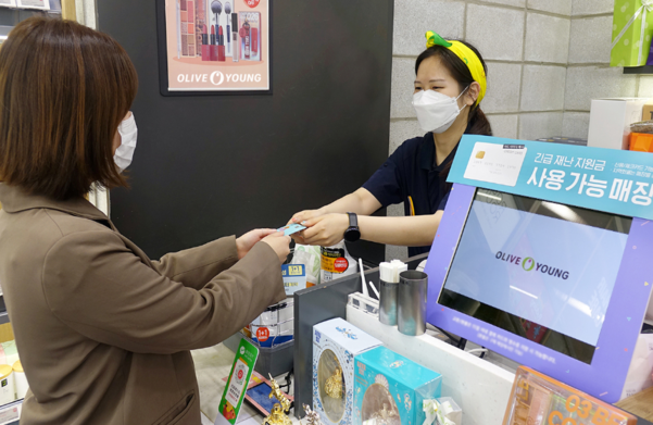 헬스앤뷰티(H&B) 스토어 CJ올리브영 매장에서 한 소비자가 긴급재난지원금을 사용해 상품을 구매하는 모습. /CJ올리브영 제공