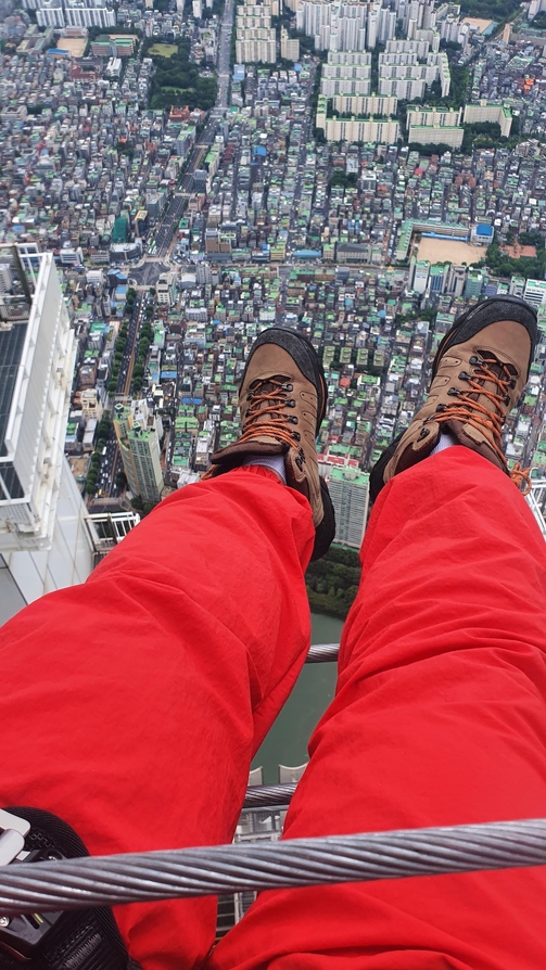 스카이브릿지에 걸터 앉아 다리를 뻗었다. 다리 밑으로 건물들이 성냥갑보다 작게 보인다. 이 때부터 높이가 체감되기 시작했다./윤희훈 기자