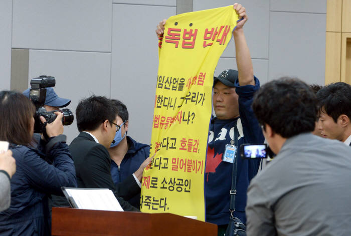 2013년 4대 중독예방관리제도 마련 공청회가 울 여의도 국회의원회관에서 열렸다. 토론 진행 중 한 참석자가 중독법 반대 플래카드를 펼치려하자 관계자들이 제지하고 있다. 박지호기자 jihopress@etnews.com