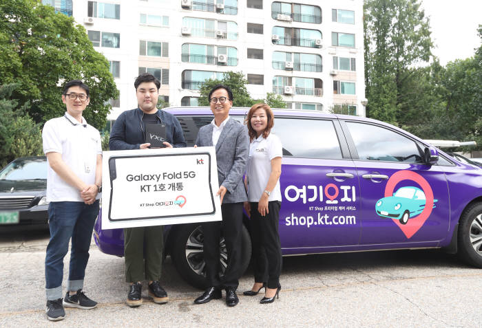 고충림 KT 전략채널본부장(왼쪽 셋째)이 KT샵 여기오지 서비스로 KT 갤럭시 폴드 5G 1호 가입자 이우성(왼쪽 둘째)씨에게 단말을 전달했다.