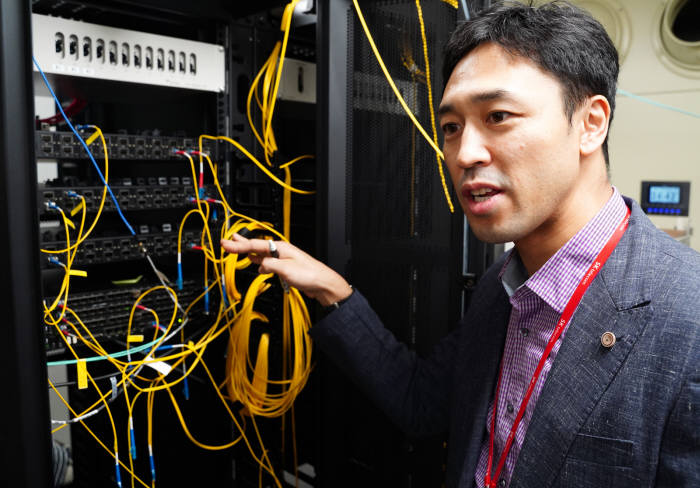 SK텔레콤 분당사옥 5G 인빌딩 테스트베드에서 SK텔레콤 연구원이 레이어 스플리터(삼성향) 장비를 소개하고 있다.