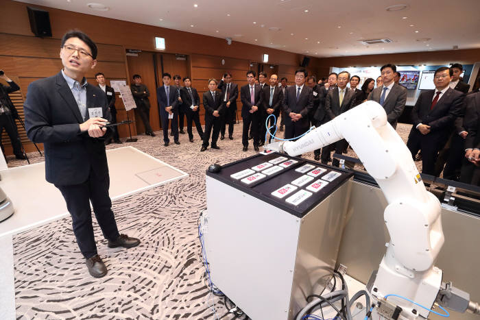 양사 임원이 AI음성인식 협동로봇 시연을 보고 있다.
