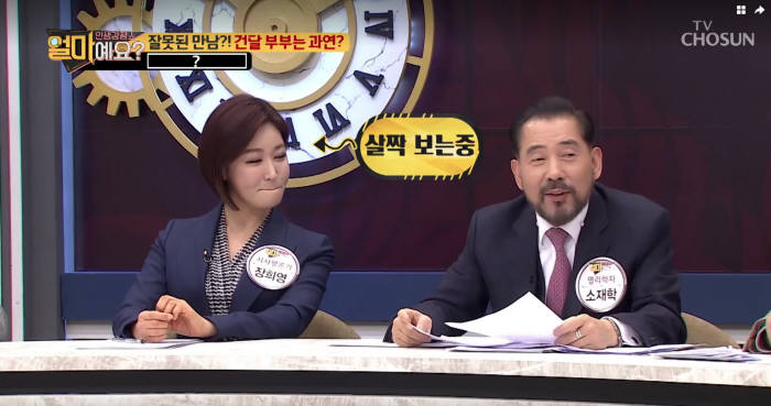 소재학 교수(오른쪽)가 부부궁합과 운세풀이를 전하자 시사평론가 장희영 교수가 엿보고 있다. 화면출처 TV조선