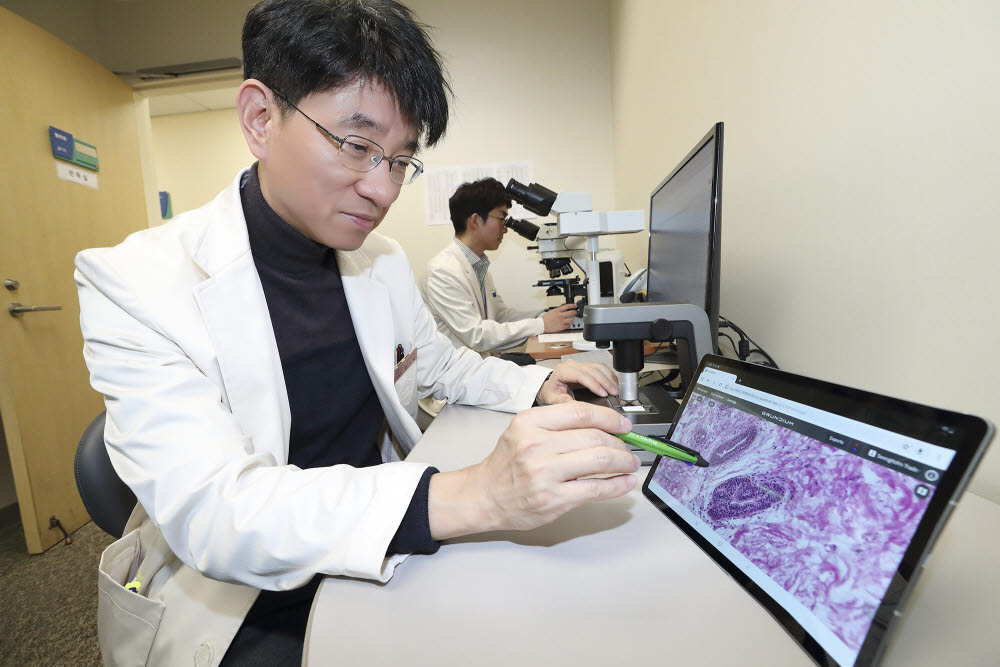 삼성서울병원 집무실에서 병리과 교수가 방금 촬영된 환자의 병리 데이터를 확인하고 있다. (사진=KT)