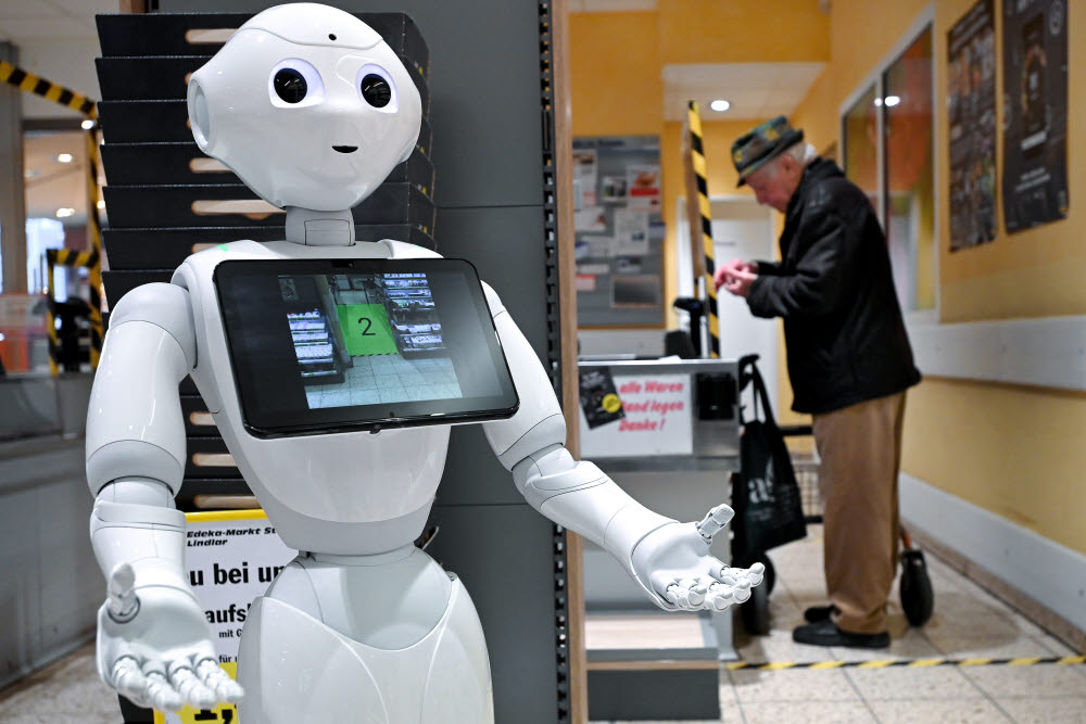 epaselect epa08333486 A humanoid robot named apos;Pepperapos; interacts with shoppers at a supermarket belonging to the Edeka chain, in Lindlar, western Germany, 31 March 2020. Pepper, who was actually developed as a robotic nurse, helps customers keep a safe distance between each other in order to minimize transmission of the SARS-CoV-2 coronavirus that causes the pandemic COVID-19 disease. According to the German federal disease control agency, the Robert Koch Institute, the number of COVID-19 cases in Germany has exceeded the 67,000 mark, while some 650 deaths have been recorded so far. EPA/SASCHA STEINBACH