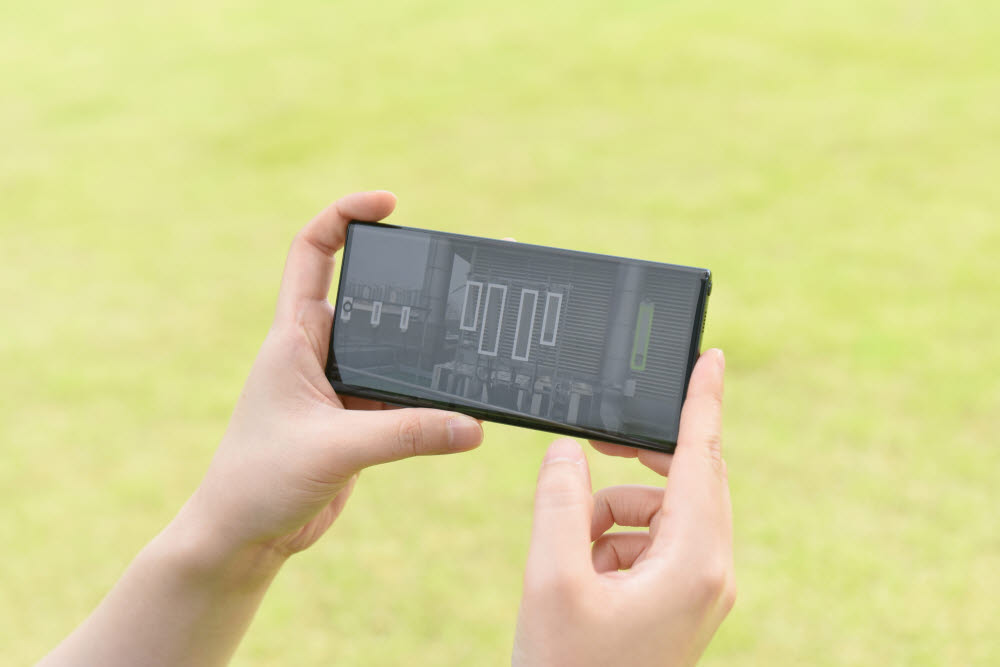삼성 5G 네트워크 성능 최적화 솔루션을 탑재한 드론으로 촬영한 안테나와 기지국 정보를 스마트폰으로 확인하는 모습