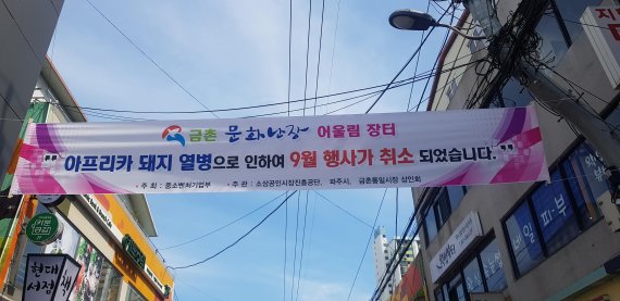 19일 파주시 금촌전통시장에 아프리카돼지열병 발병으로 문화행사 '어울림 장터'를 취소한다는 현수막이 내걸려 있다. 사진=이용안 인턴기자