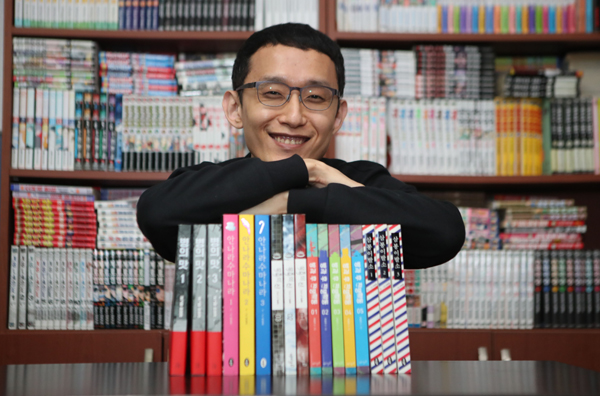 하일권 작가가 작품과 함께 촬영하며 활짝 웃고 있다. [이승환 기자]