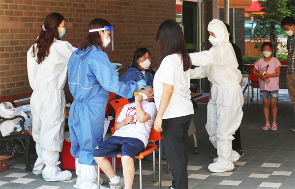 인천 지역에서 코로나19 확진자가 속출하는 가운데 29일 교사가 확진 판정을 받은 인천 백석초등학교에 마련된 선별진료소에서 학생들이 검체를 채취하고 있다. [이충우 기자]