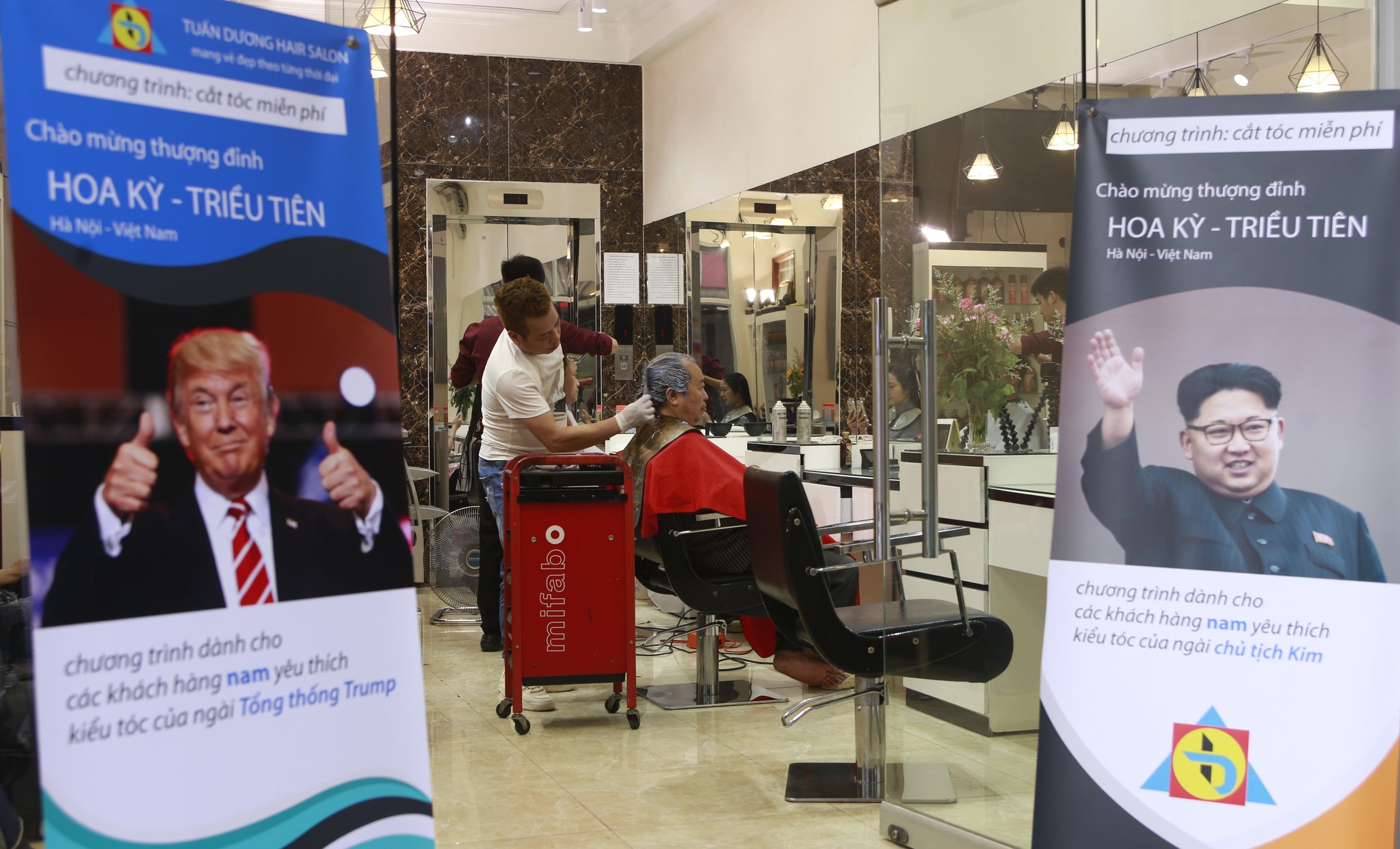 북미정상회담을 맞아 트럼프와 김정은 헤어스타일을 원하는 고객에게 무료 서비스를 제공하고 있는 투안 두옹 뷰티 아카데미. [AP=연합뉴스]