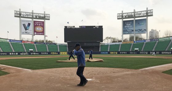 미세먼지 농도가 '나쁨'을 기록한 지난해 4월 6일 서울 잠실야구장에서 열릴 예정이던 프로야구 NC와 두산의 경기가 취소되자 경기장 관계자들이 그라운드를 정리하고 있다. [연합뉴스]