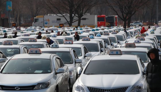 택시 요금이 인상된 직후인 지난달 18일 경기도 과천 서울대공원 주차장에서 택시 기사들이 차량을 주차하고 미터기 수리 순서를 기다리고 있다.［연합뉴스］