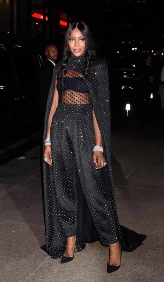 모델 나오미 캠벨의 화려한 하객 패션. 늘어뜨린 케이프 디자인이 돋보이는 발망의 수트다.