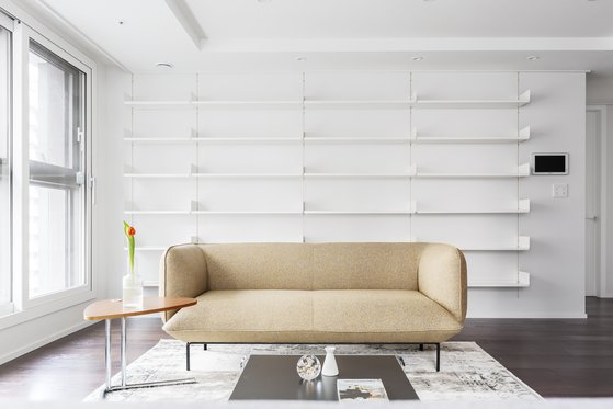 서울 송파구 박정현씨의 거실. 책을 수납하되 수납장이 돋보이는 것이 싫어 선택한 깔끔한 디자인의 모듈 선반 시스템. 벽면 사이즈에 딱 맞게 설치할 수 있다. [사진 아파트멘터리]