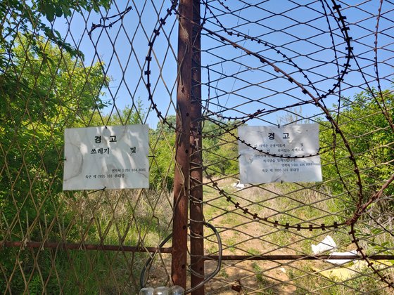 불법 투기 경고문이 붙어 있는 경기도 연천군의 한 국방부 소유 부지. 안쪽 곳곳에 100t가량의 불법 투기 폐기물이 방치돼 있다. 김민욱 기자