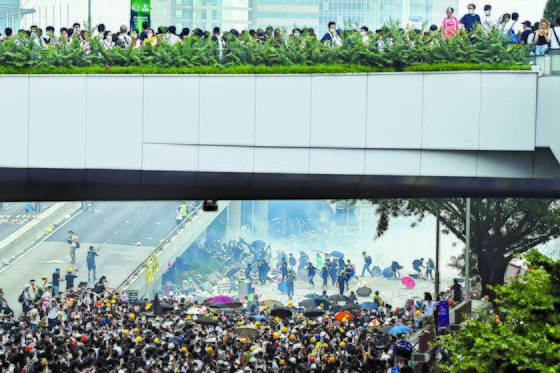 지난 6월 9일 범죄인 인도 법안을 거부하며 홍콩 거리를 가득 메운 시위대를 경찰이 최루탄을 발사하며 해산시키려 하고 있다. [AFP=연합뉴스]